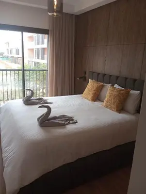 a bedroom with a large bed with a large window at Domaine de Noria Isli 2 - Magnifique 2 chambres - Vue directe sur la piscine in Marrakech