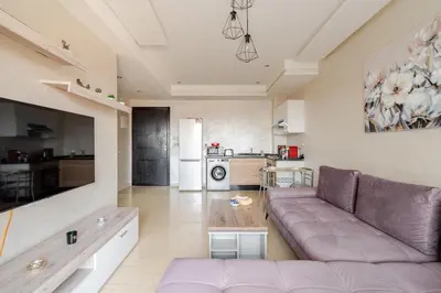 a living room with a couch and a kitchen at Cosy appartement au centre ville hivernage marrakech in Marrakech