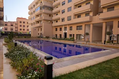 a large swimming pool in front of a building at Golden Palm Resort in Marrakech