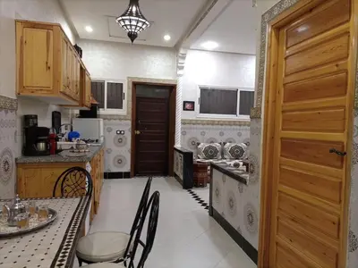 a kitchen with a table and chairs and a door at MARRAKECh TYPICAL & CONFORT APPARTEMENT in Marrakech