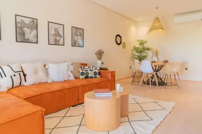 a living room with an orange couch and a table at Wonderfull Place in Marrakech - Pool Wifi Terrace in Marrakech