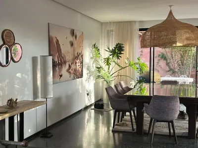 a dining room with a glass table and chairs at Villa Sissi Marrakech in El Rhechat