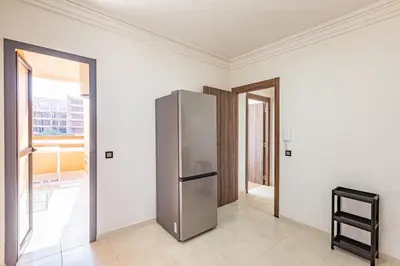 a stainless steel refrigerator in a room with windows at New! appt Nour Confort avec piscine & wifi in Marrakech