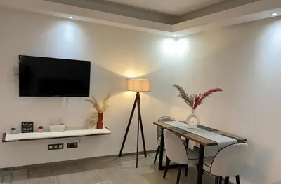 a living room with a table and a television on a wall at Ruby in Marrakech