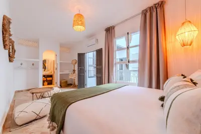 a bedroom with a large white bed and a window at Riad Dar Jamila Breakfast 10mn to Jamaa Al Fna in Marrakech