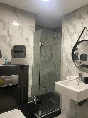 a bathroom with a shower and a sink and a mirror at La perle in Marrakech