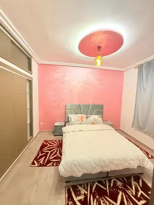 a bedroom with a bed and a pink wall at Appartement Calme Parfait & Centre-ville in Marrakech