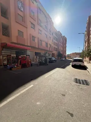a street with a building and cars parked on the road at Appartement Calme Parfait & Centre-ville in Marrakech