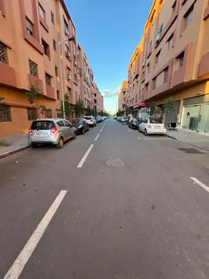 an empty city street with parked cars and buildings at Appartement Calme Parfait & Centre-ville in Marrakech