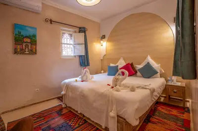 a bedroom with a bed with two swans on it at Dar Flora in Marrakech