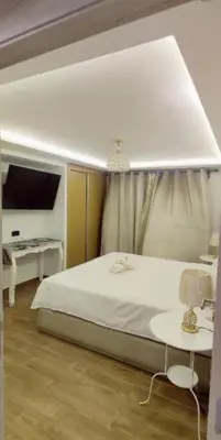 a bedroom with a large white bed and a tv at Luxury Family Duplex in the Best Area of Marrakech with Pool and Garden in Marrakech