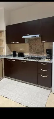 a kitchen with brown cabinets and a counter top at Cozy appartment in Marrakech