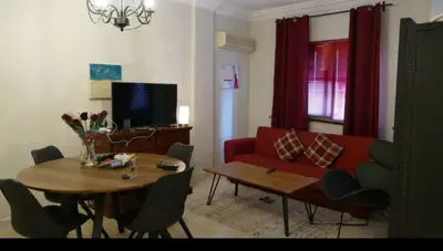 a living room with a red couch and a table at Appartement ilyaS in Marrakech