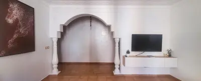 a white room with a television on a wall at Well-equipped apartment for rent in Marrakech
