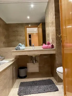 a bathroom with a sink and a toilet and a mirror at appartement luxueuse in Marrakech