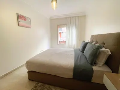 a bedroom with a large bed and a window at appartement luxueuse in Marrakech