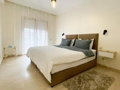 a bedroom with a large bed and a window at appartement luxueuse in Marrakech