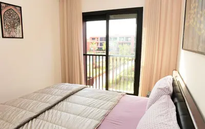 a bedroom with a bed and a window with a balcony at Welcome Home! in Marrakech