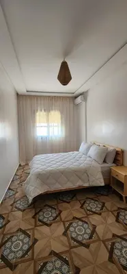 a bedroom with a large bed in a room at الراحة والسلامة مراكش in El Gouassem