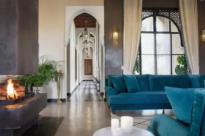 a living room with a blue couch and a fireplace at Daba Riads in Marrakech