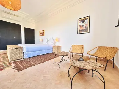 a bedroom with a bed and two chairs and a table at Villa Zaria Marrakech Heated Pool Family Friendly 25 Min To Medina in Marrakech