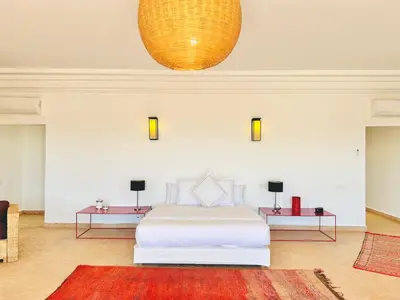 a bedroom with a white bed and two tables at Villa Zaria Marrakech Heated Pool Family Friendly 25 Min To Medina in Marrakech