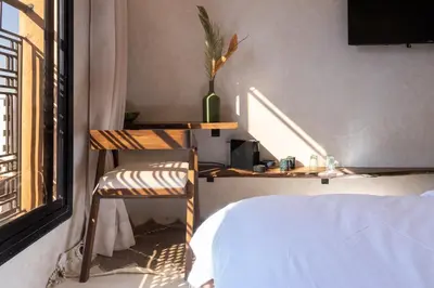 a bedroom with a desk and a bed and a window at Suite cosy en hypercentre in Marrakech