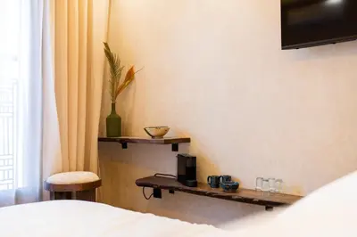 a bedroom with a bed and a chair and a window at Suite cosy en hypercentre in Marrakech