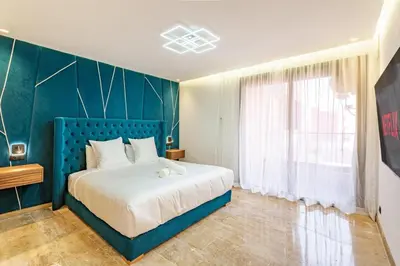 a bedroom with a bed with a blue headboard and a window at Studio Ali gueliz in Marrakech