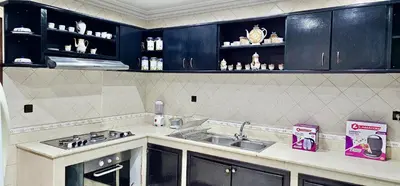 a kitchen with black cabinets and a sink at Luxury apartment in Gueliz, near the Majorelle Garden and Yves Saint Laurent Museum in Marrakech