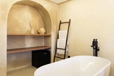 a bathroom with a white tub and a shelf at Suite luxueuse avec baignoire ouverte in Marrakech