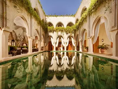 a courtyard with a pool of water in a building at rid kalim in Marrakech