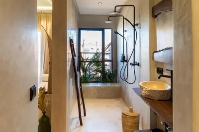 a bathroom with a sink and a shower with a window at Suite avec vue époustouflante sur les jardins majorelle in Marrakech