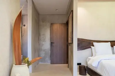 a bedroom with a bed and a wooden door at Suite avec vue époustouflante sur les jardins majorelle in Marrakech