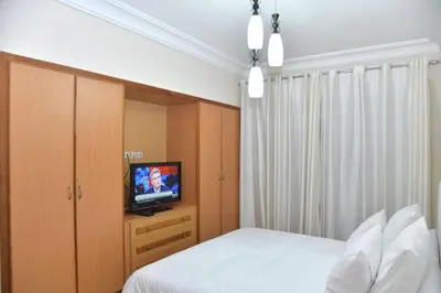 a bedroom with a bed and a flat screen tv at Ideal family apartment in Marrakech