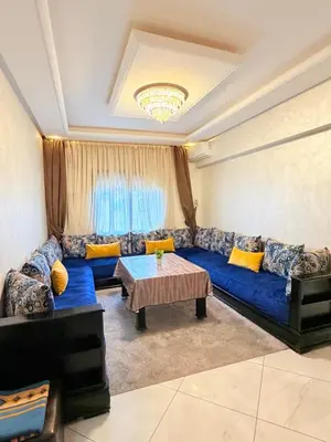 a living room with a blue couch and a table at Appartement N15 Lumineux Calme & Centre-ville in Marrakech