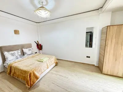 a bedroom with a bed and a wooden floor at le numéro 7 in Marrakech