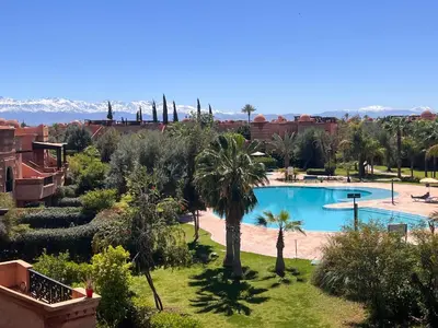 a resort with a swimming pool and palm trees at Your Getaway Oasis in the Lush Resort in Marrakech