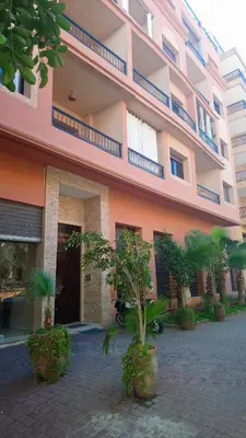 a pink building with trees in front of it at Résidence Jasmin 2 Marrakech Gueliz in Marrakech
