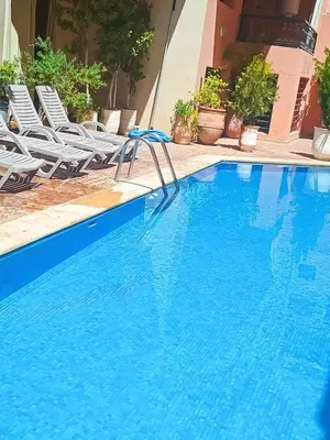 a large blue swimming pool with chairs next to it at Résidence Jasmin 2 Marrakech Gueliz in Marrakech