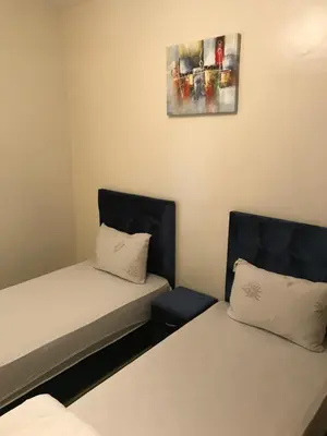a room with two beds and a picture on the wall at Appartement Simouni in Marrakech