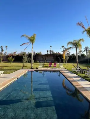 a swimming pool with palm trees in the background at villa abraj in Marrakech