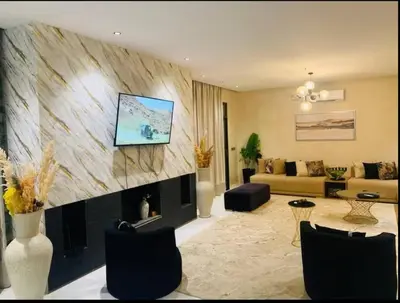 a living room with a fireplace with a tv above it at villa abraj in Marrakech