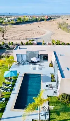 a house with a swimming pool next to a beach at villa abraj in Marrakech