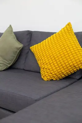 a yellow pillow sitting on a gray couch at Majorelle Elegance City Center in Marrakech
