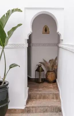 a hallway with white walls and a potted plant at Riad Privatif avec Personnel et Services Exclusifs - Kasbah Boma Marrakech I in Marrakech