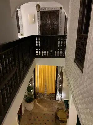 a stairway with a door with a yellow curtain at Riad bab Adam in Marrakech