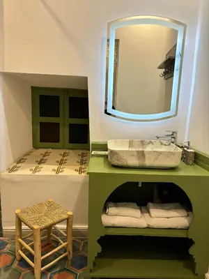 a bathroom with a sink and a bed at Riad bab Adam in Marrakech