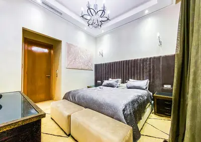 a bedroom with a bed and a chandelier at Heated Pool Villa in Marrakech