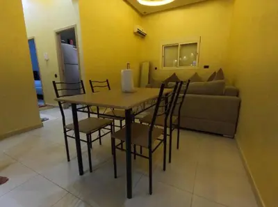 a table and chairs in a living room with a couch at Appartement en résidence in Marrakech